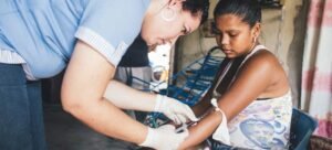 Uma profissional de saúde coleta amostras de sangue de uma mulher que já havia contraído dengue. (arquivo)