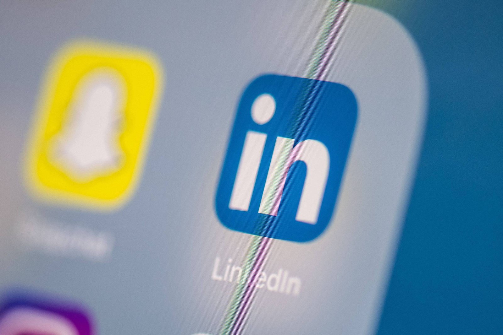 A imagem mostra um close do ícone do aplicativo LinkedIn, que é um quadrado azul com a letra