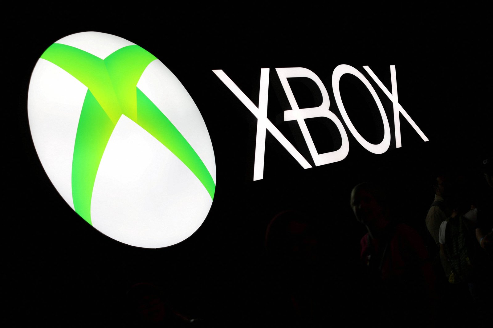 A imagem mostra o logotipo da marca Xbox, que consiste em um círculo branco com um símbolo verde em forma de