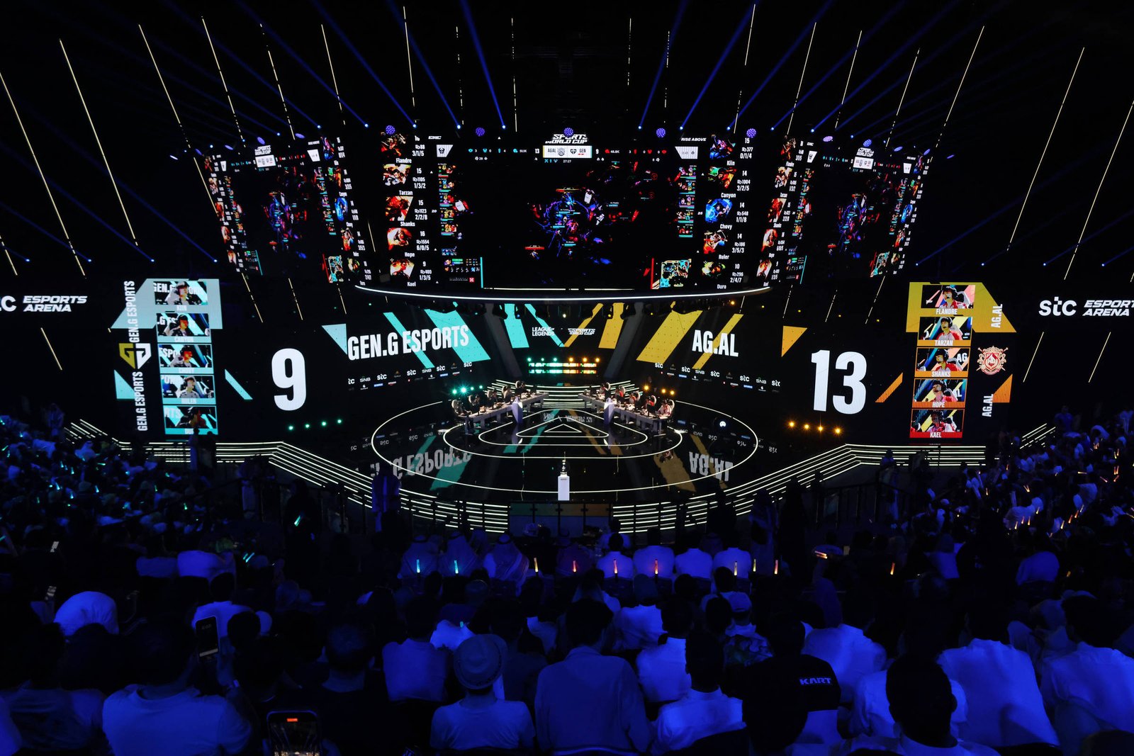 Arena de eSports com público assistindo partida entre Gen.G Esports e AGAL. Placar mostra 9 a 13 para AGAL, com jogadores nas estações e telas grandes exibindo o jogo.