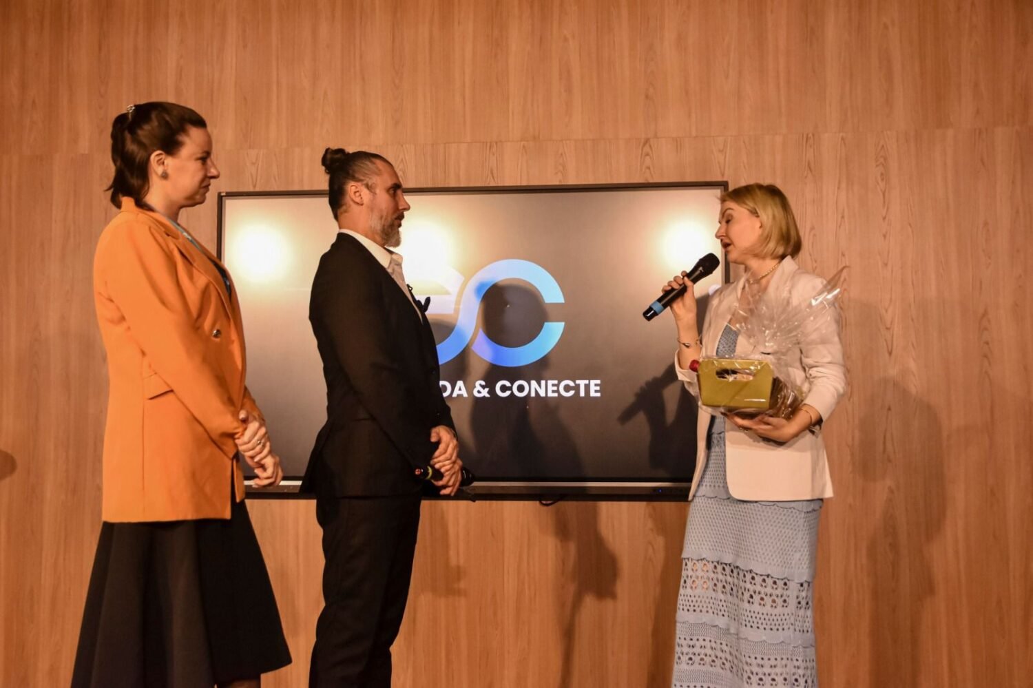 Vanice Jacoboski no palco durante uma apresentação, transmitindo confiança e autoridade em finanças estratégicas.