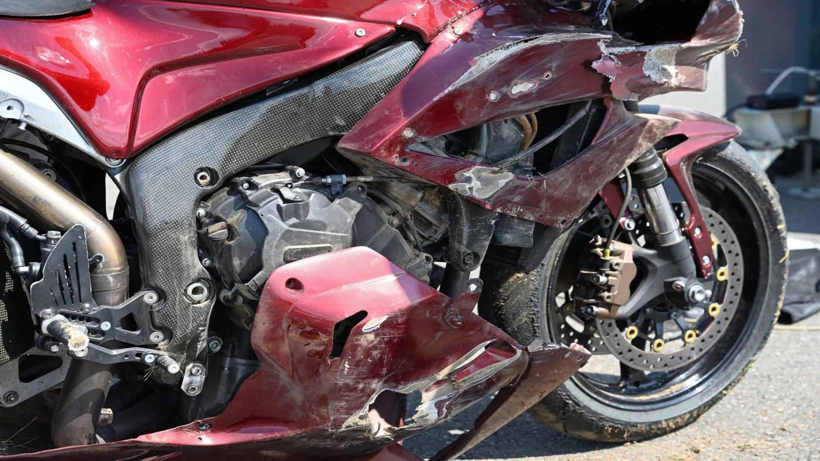 Imagem mostra close de motocicleta esportiva danificada após uma queda em uma corrida