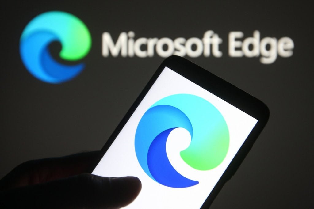 Logo do Microsoft Edge ao fundo, desfocado, e, à frente, o logo em um smartphone