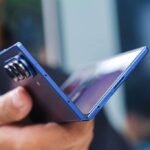 Pessoa segurando um Samsung Galaxy Z Fold7; ângulo mostra o smartphone parcialmente aberto e de cima