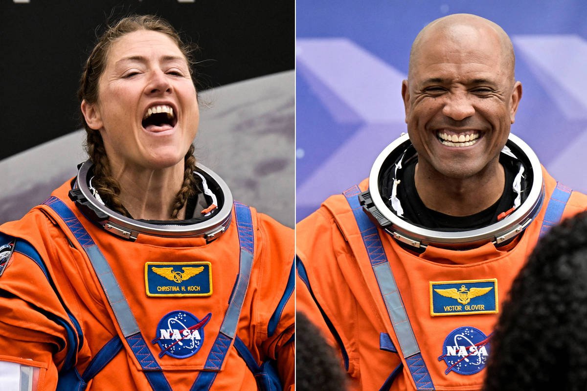 Dois astronautas vestindo trajes espaciais laranja da NASA aparecem em imagens lado a lado. À esquerda, mulher com tranças sorri com boca aberta contra fundo escuro. À direita, homem careca sorri amplamente diante de fundo azul com padrão geométrico.