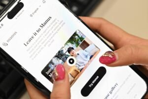Mãos seguram smartphone exibindo página inicial do aplicativo Manus, com texto