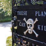 Placa preta em portão de ferro com texto em inglês