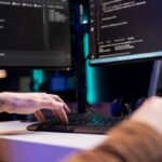 Desenvolvedor que digita código no computador para a rede da empresa à prova de tempo de inatividade e falhas inesperadas do sistema. Muitos script de programação de implantação aumentando a segurança dos dados